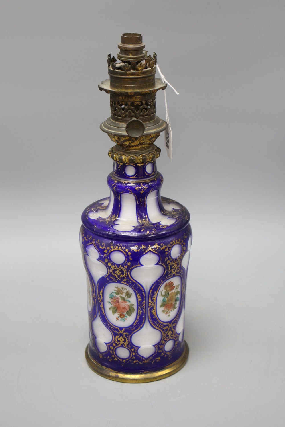 A Bohemian blue overlaid glass oil lamp base, painted with flowers, overall height 42.5cm